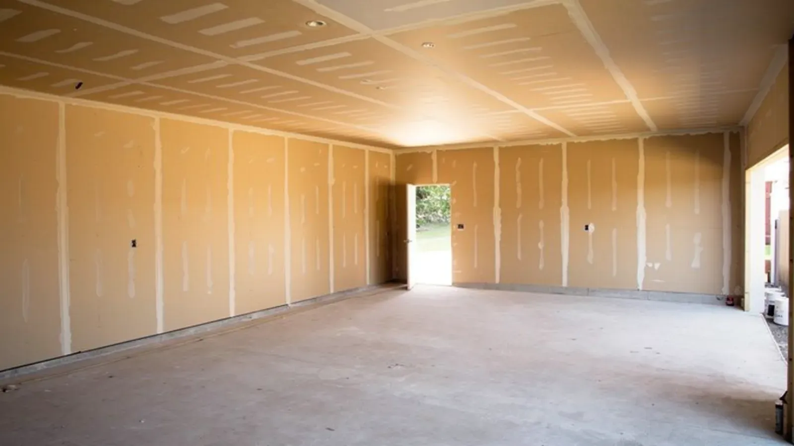 Fire-rated drywall assembly taped across a garage ceiling and side walls
