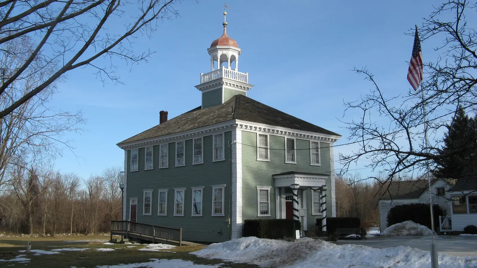 Historic green-clapboard town building with a white cupola and red dome, Westford, Massachusetts